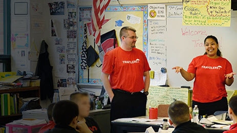 Travelers volunteers reading to children