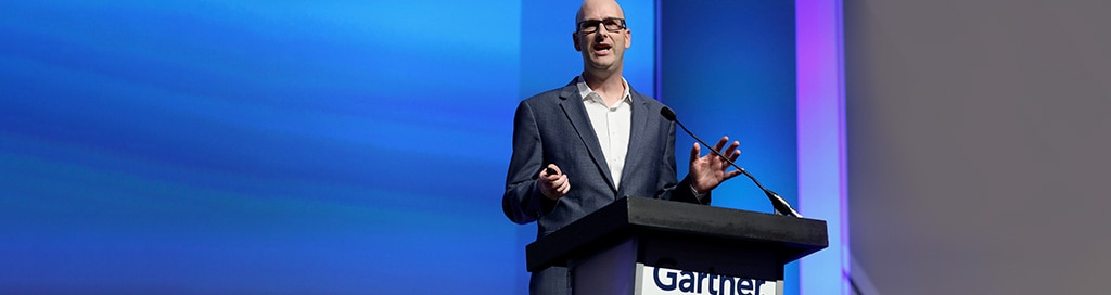 Man speaking at podium with Gartner