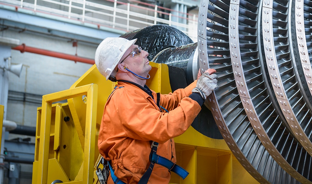 Engineer inspecting a huge machine with layers of discs.