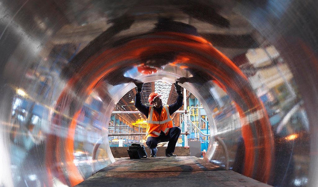 man looking into metal tube