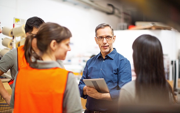 Man with clipboard talking to people