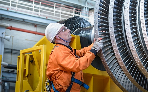Engineer inspecting a huge machine with layers of discs.
