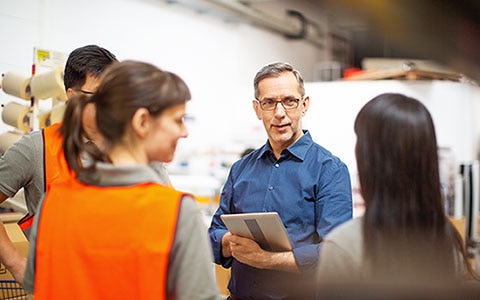 man with clipboard talking to team