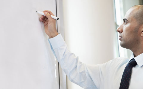 Business professional writing on white board