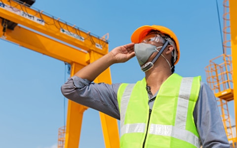 Construction worker looking up with mask on