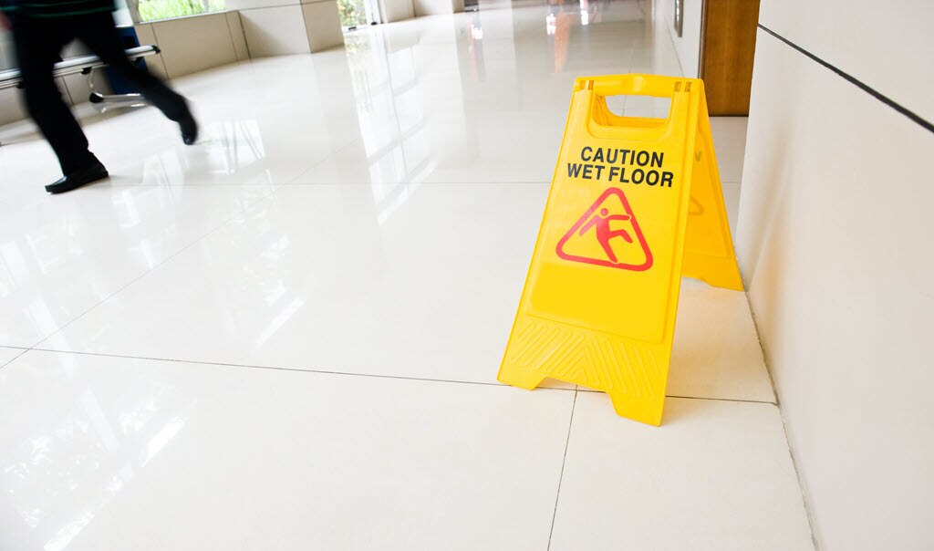 a caution, wet floor sign on the floor of a business