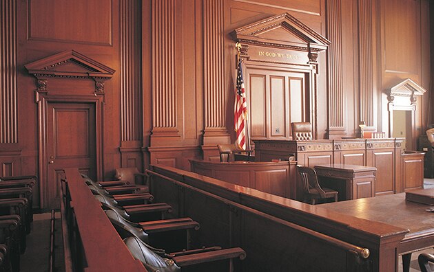 An empty courtroom with focus on the judge and jury seats
