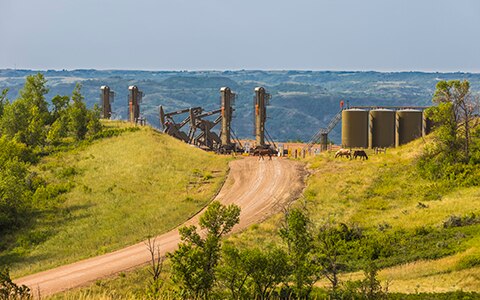 shot of Enerplus site with horses on trail