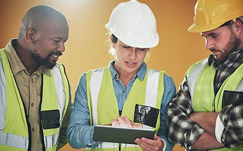 Three construction workers in safety wears having a meeting