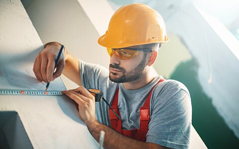 Contractor measuring a wall