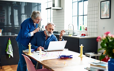 An older couple looking at a laptop together