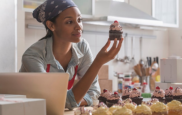 small business owner in her bakery looking at a cupcake, Benefits of Insurance Bundling for Small Business Customers