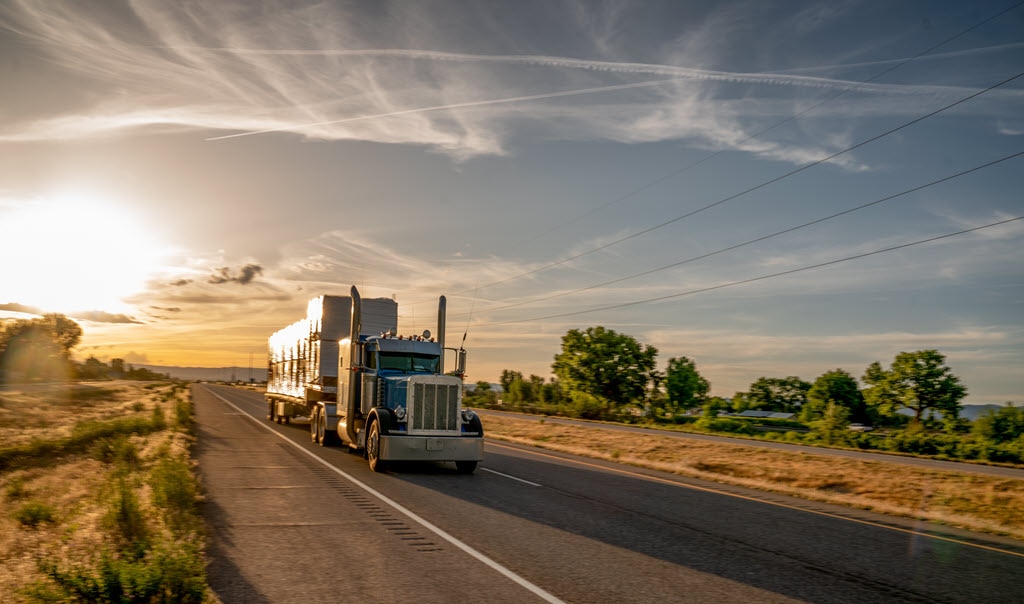 tractor trailers on road, sun rise