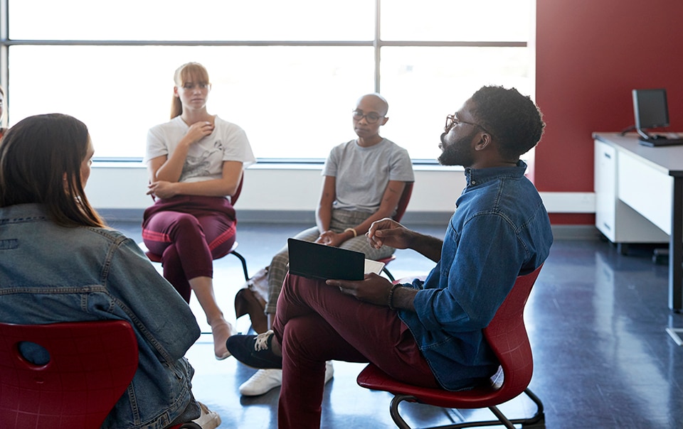 People gathered around a seated roundtable discussion