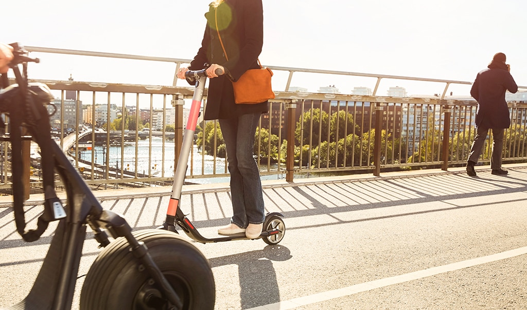 man on street getting an e-vehicle scooter