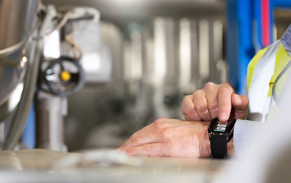 employee on construction site checking wearable watch