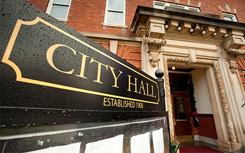 city hall sign in front of building