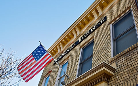 exterior of municipal building with American flag