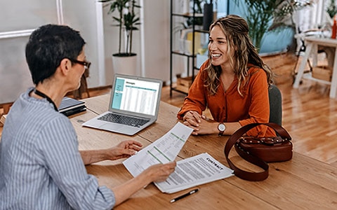 Small business owner interviewing a job candidate, seated at a desk