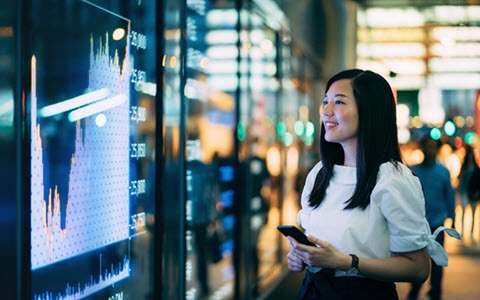 woman looking at screens with finance information