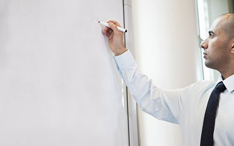 Man writing business continuity plan on white board