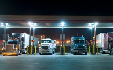 Image of a row of semi trucks at a gas station. Pilferage and Seal Break Events Can Be Costly [Infographic]