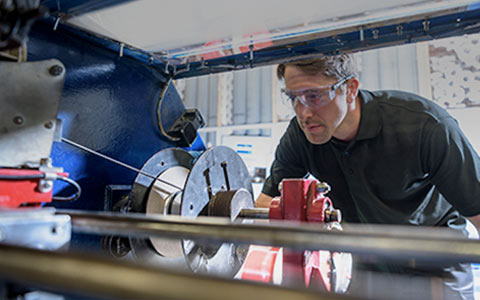 Manufacturing worker using equipment