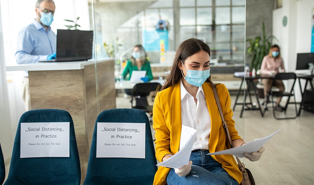 Woman with mask on sitting in waiting room