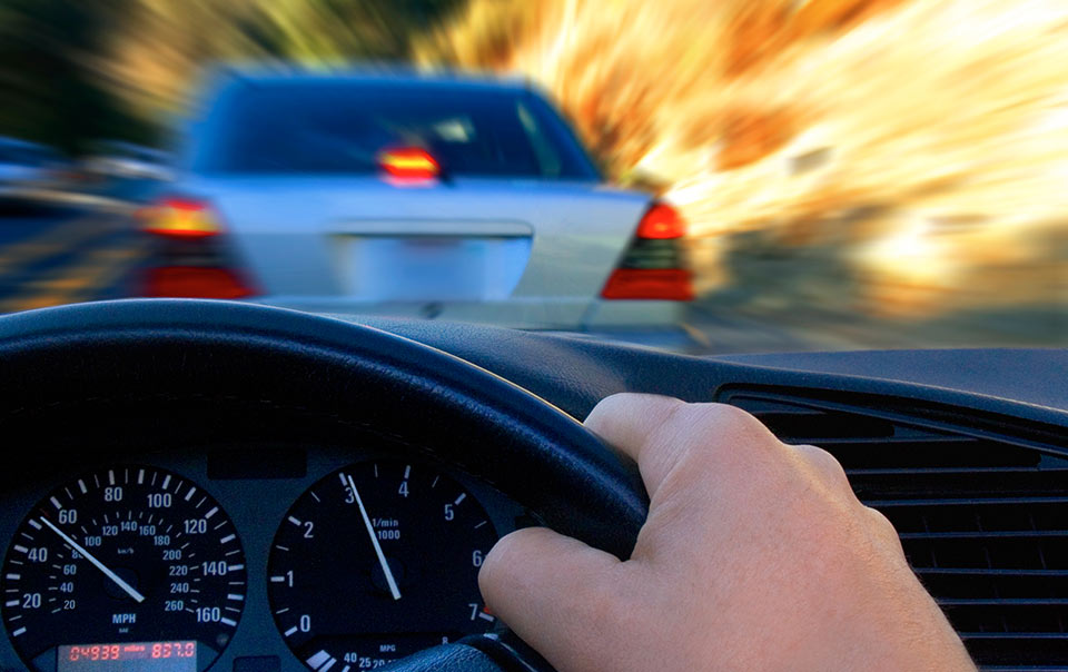 Person driving behind a car and sharing the road with another car