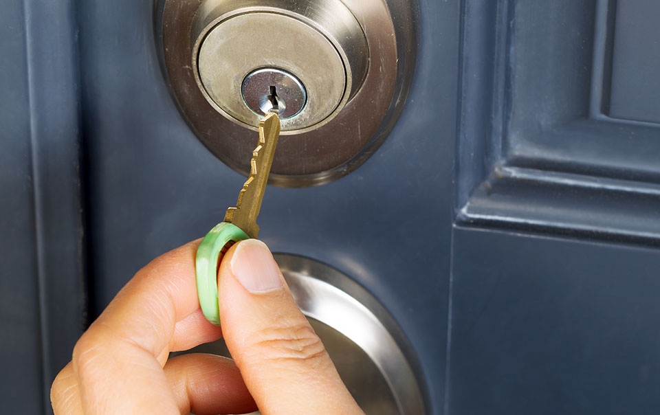Person preparing home for vacation by locking door