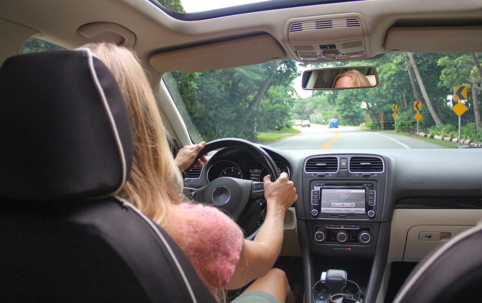 image taken from back seat of a car of woman driving a car, How Telematics Can Help Improve Driver Safety 
