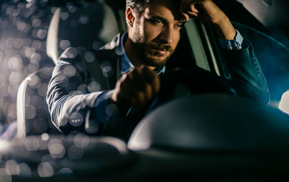 Driver falling asleep behind wheel of car at night