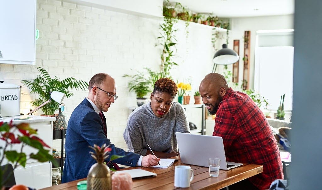 A couple talking with an advisor in their kitchen