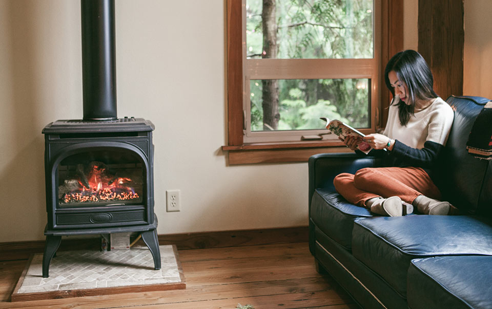 Woman sitting on sofa in front of a pellet stove