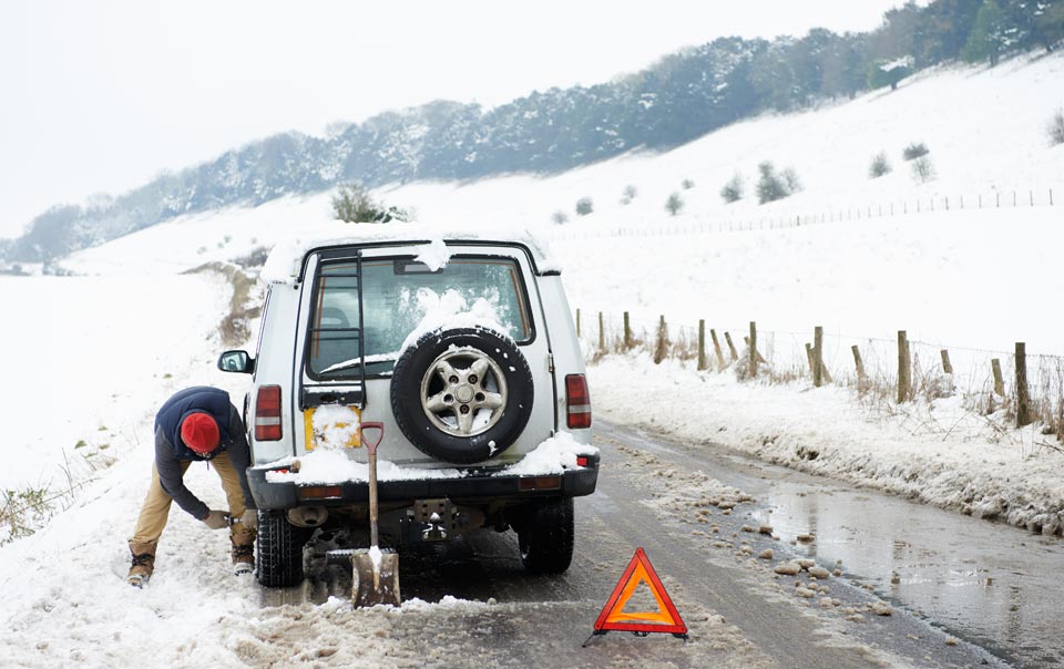 Person winterizing car on the side of the road