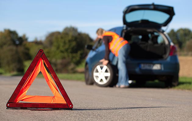 person changing a tire after a tire blowout