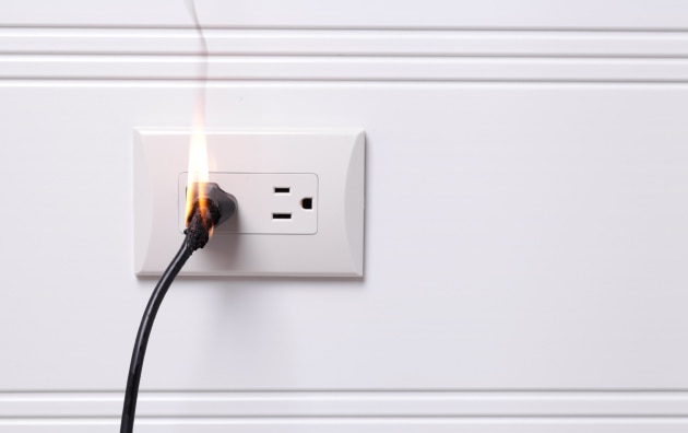 Wall outlet, plugged in with a small electrical fire.