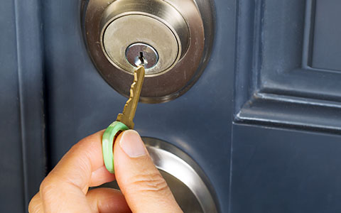 Person locking door before going on vacation