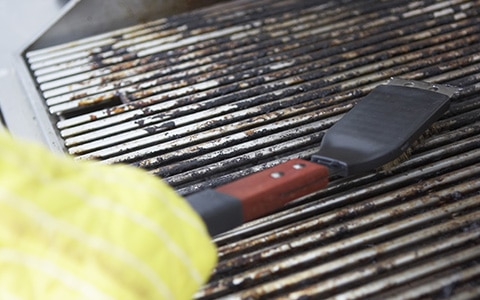 Person cleaning a gs grill