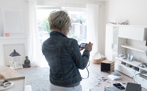 image of woman taking pictures of home after break-in and theft, Does Renters Insurance Cover Theft?