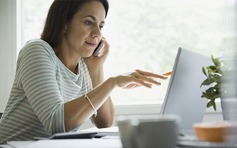 woman looking at laptop-Why Did My Homeowners Insurance Go Up?