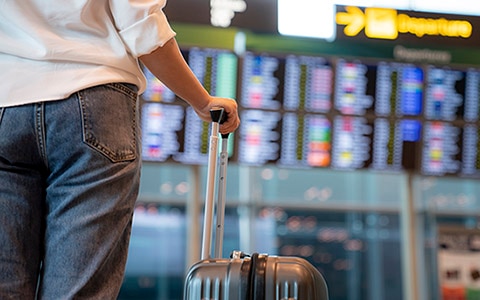 man holding suitcase in airport