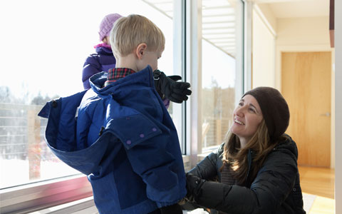 Mom zipping up jacket of son 