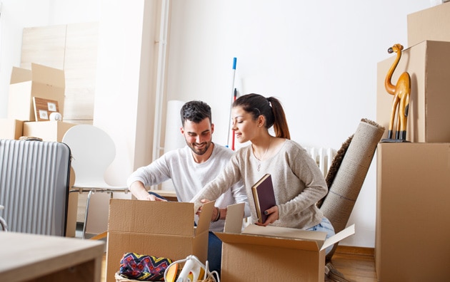 Couple unpacking boxes in apartment