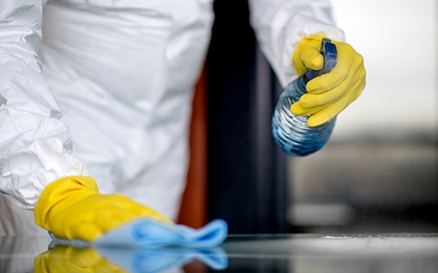 person in ppe cleaning work surface, Cleaning and Disinfecting During and After a Pandemic
