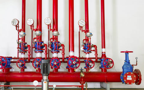 A group of red water pipes that make up the sprinkler system.
