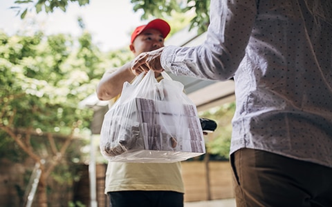 Delivery driver handing food over to customer