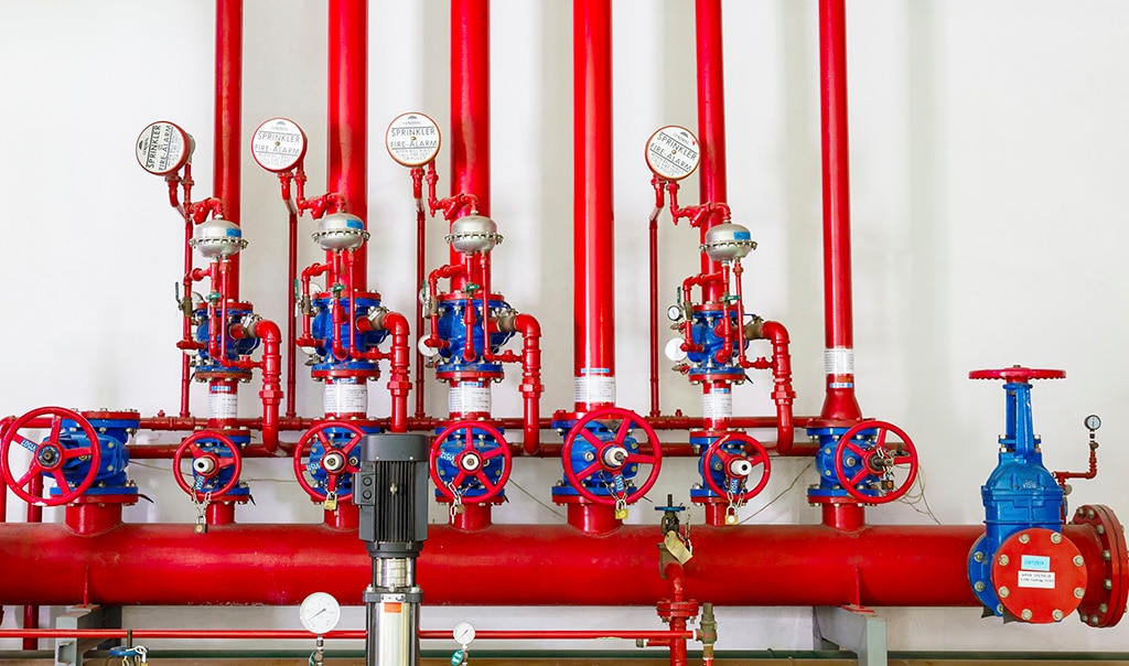 A group of red water pipes that make up the sprinkler system.