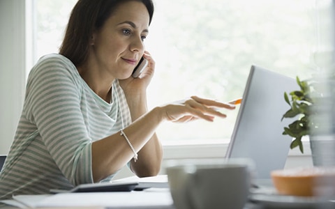 woman at home using a computer at desk