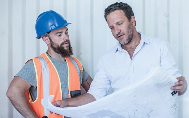 man and construction worker looking at plans
